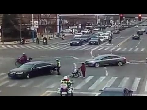 2 police officers escort a senior citizen across road